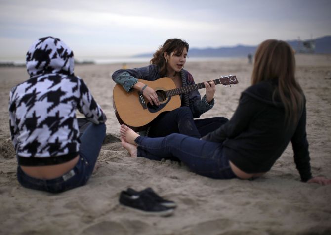 Teenagers play the guitar on Venice Beach in Los Angeles.