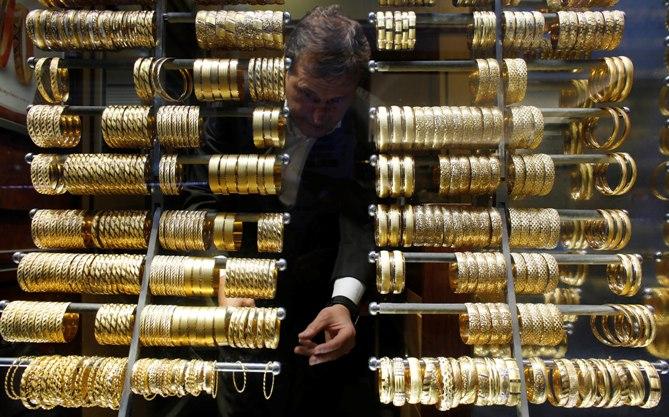 A goldsmith arranges gold bangles at a jewellery shop.