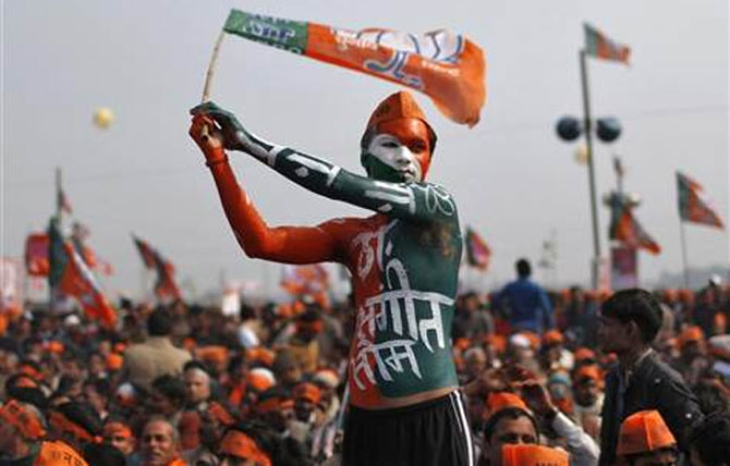A supporter of Bharatiya Janata Party waves the party's flag during a rally being addressed by Gujarat's Chief Minister Narendra Modi.