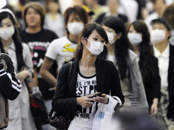 People wear face masks at a shopping street in Kobe, western Japan.