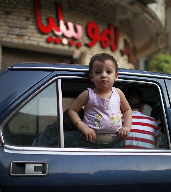 A child looks outside a car window in Cairo.