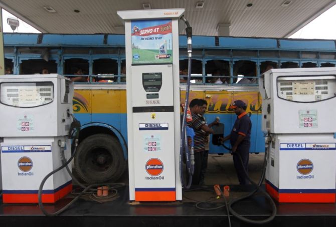 An employee fills diesel in a public bus at a fuel station in Kolkata.