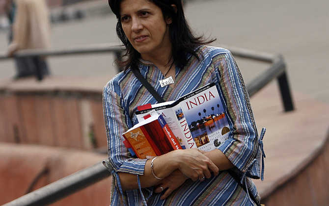 A foriegn tourist holds guide books as she visits the Red Fort in the old quarters of Delhi.