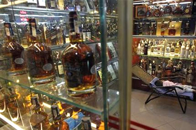  A child sleeps at a shop selling whisky in Hanoi.