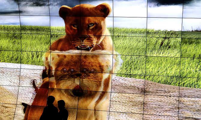 Visitors pass a 3D TV screen installation by LG during the IFA consumer electronics fair in Berlin, Germany.