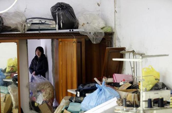 Shen Jianhe looks on as police officers conduct a check at the Shen Wu textile factory in Prato.