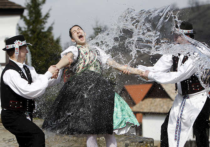 Boys hold onto a girl as they throw water at her as part of traditional Easter celebrations in Holloko, 100km east of Budapest, Hungary.