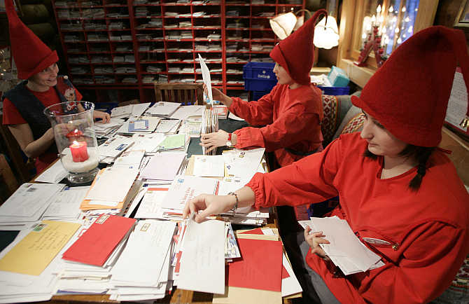 People dressed as elves read letters from around the world which were sent to Santa Claus at the Santa Claus' Post Office on the Arctic Circle near Rovaniemi, northern Finland.