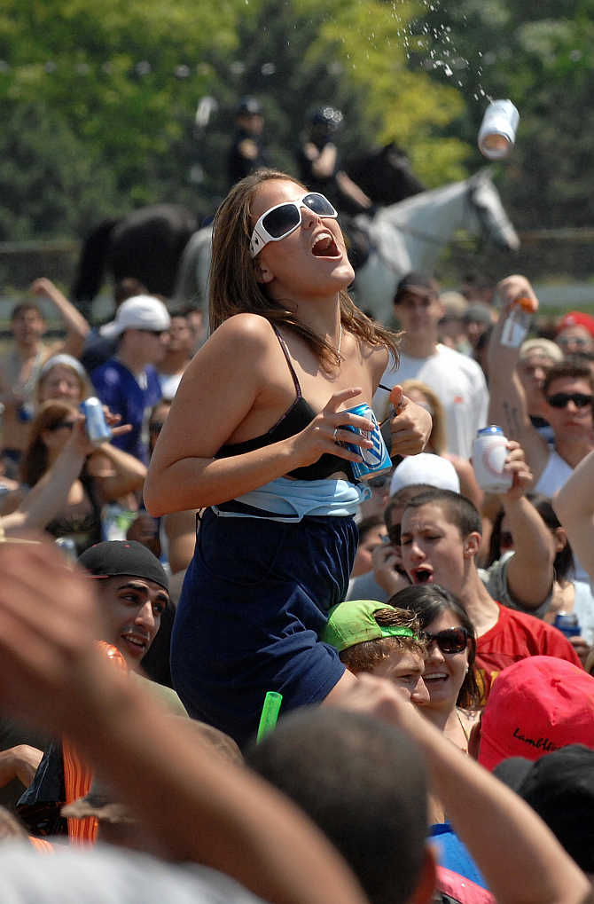 A woman dodges a flying beer can at Pimlico Race Course in Baltimore, Maryland, United States.