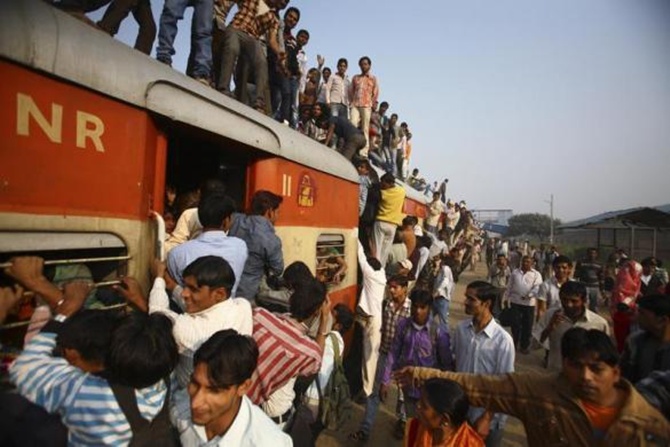 Commuters struggle to board a train at Noli railway station in Uttar Pradesh.
