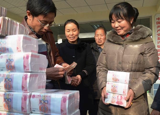 Ling Xuxia collects her 314,000 yuan ($51,935) year-end bonus at Jianshe village, Liangshan, Sichuan province, January 14, 2014.