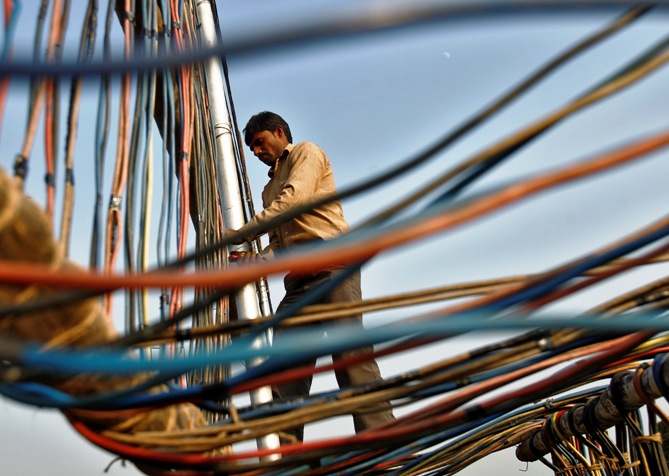 An electrician installs power cables outside the Indian Parliament building in New Delhi.