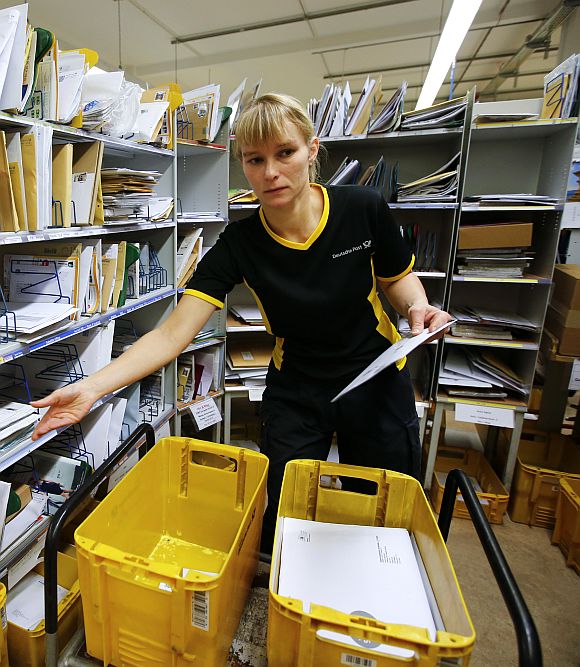 Sabine Standke, 32-year-old postwoman of the German postal and logistics group Deutsche Post, sorts mail at a sorting office in Berlin's Mitte district.
