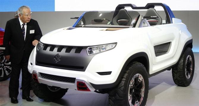 Suzuki Motor Corp Chairman and Chief Executive Officer Osamu Suzuki looks at its X-Lander concept car at the 43rd Tokyo Motor Show.