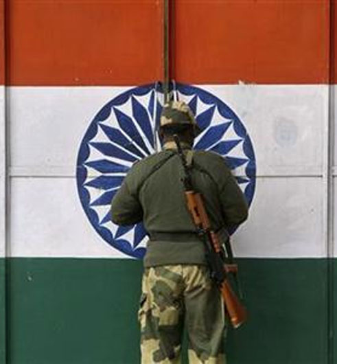An Indian Border Security Force soldier opens a gate at the border with Pakistan near Jammu.