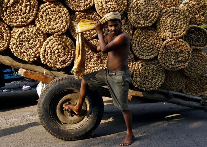 A labourer ties cloth around his head before unloading coir rolls at a wholesale market in Kolkata. Photograph: Rupak De Chowdhuri/Reuters