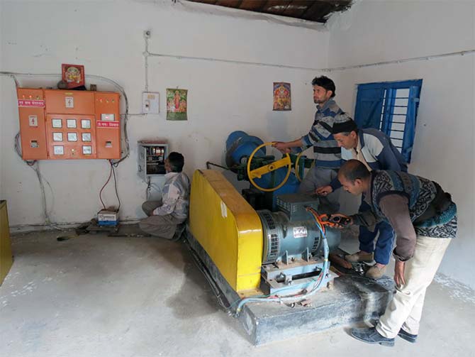 A trained grassroots engineer operates the turbine in electricity generation unit and maintains supply to the village.