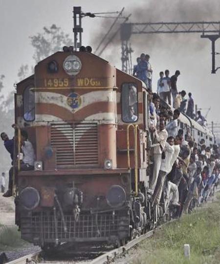 Passengers travel on an overcrowded train at Loni town in Uttar Pradesh.