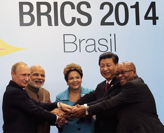 (L-R) Russian President Vladimir Putin, Indian Prime Minister Narendra Modi, Brazilian President Dilma Rousseff, Chinese President Xi Jinping and South African President Jacob Zuma join their hands at a group photo session during the 6th BRICS summit in Fortaleza.