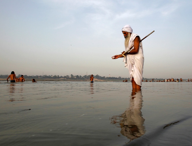 A Sadhu offers milk to the waters of holy river Ganga as part of his morning prayers in Allahabad.