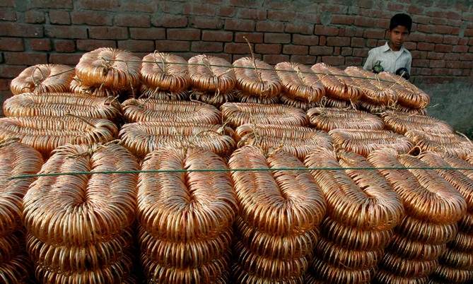A boy stands beside a heap of joined bangles in Firozabad town, about 230 km (140 miles) southeast of New Delhi.