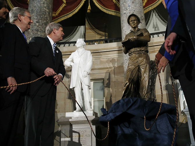 US Secretary of Agriculture Tom Vilsack (2nd L) and Senate Minority Leader Mitch McConnell (R-KY) (L) unveil a statue of Dr Norman E. Borlaug at Statuary Hall in the US Capitol in Washington. 