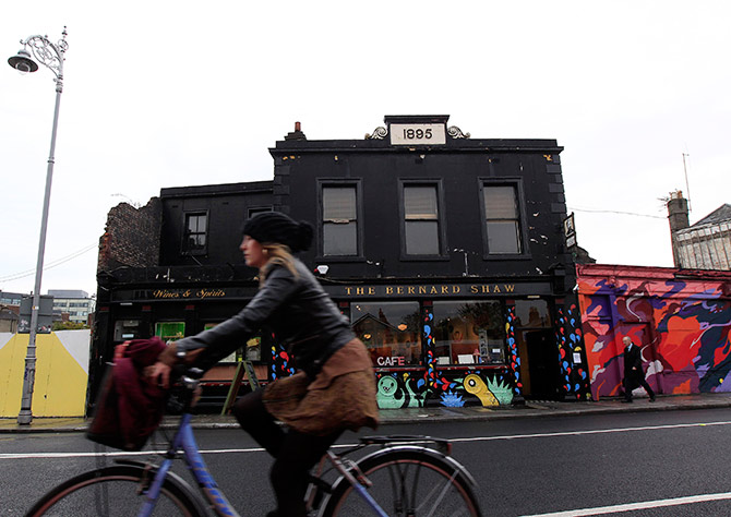 A woman cycles past the Coffee To Get Her restaurant near Dublin city centre which becomes a bar and club in the evenings.