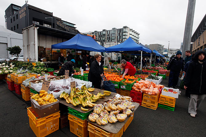 People buy fruits at a fruit and vegetable market in front of the Te Papa Museum in Wellington.