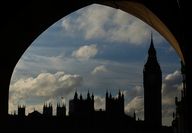 The Houses of Parliament and Big Ben are silhouetted against the sky in London.
