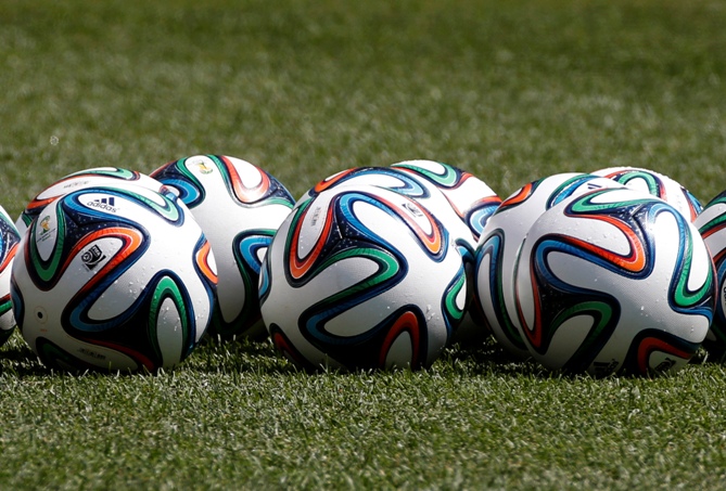 Official 2014 FIFA World Cup Brazil footballs sit on the pitch.