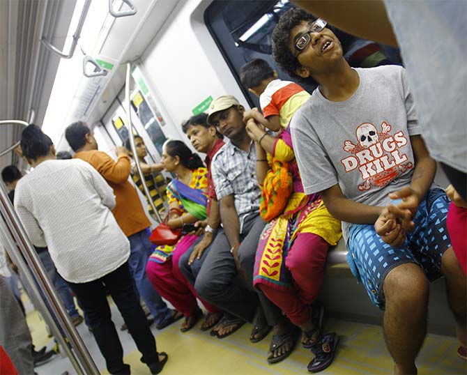 Passengers sit inside a Mumbai Metro coach.