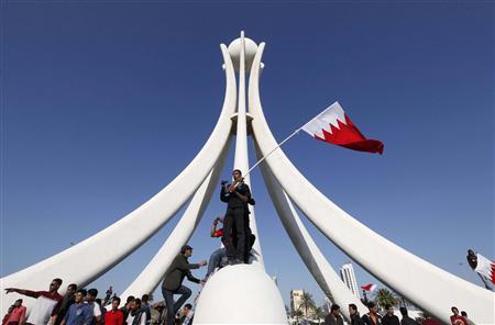 Protesters stand at the base of the Pearl Roundabout in the Bahraini capital of Manama, February 15, 2011.