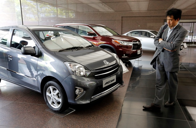 A man looks at Toyota cars at the company's showroom in Tokyo May 8, 2014. 
