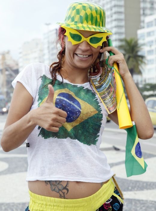 A Brazilian fan gives a thumbs up on Copacabana Beach as the 2014 FIFA World Cup nears.