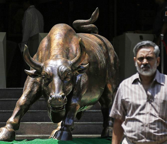 A man walks past the Bull at the Bombay Stock Exchange.