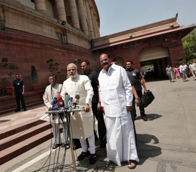 Prime Minister Narendra Modi (C) speaks with the media as he arrives to attend his first Parliament session in New Delhi June 4, 2014. 