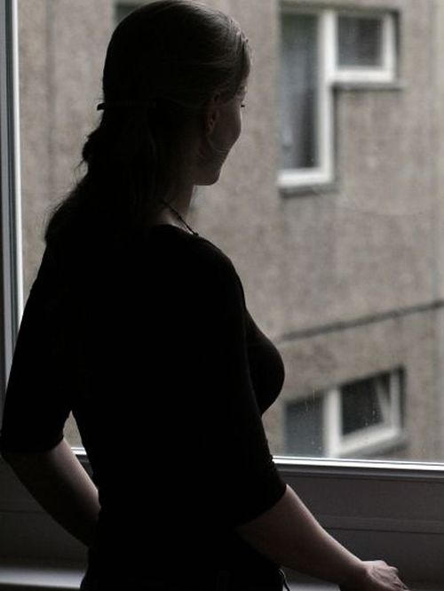 A woman silhouetted against a window.
