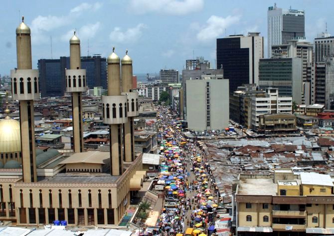 People and traffic move along a busy street in Lagos.