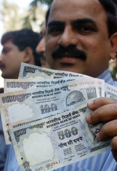 A policeman displays counterfeit currency seized in a raid in Mumbai.