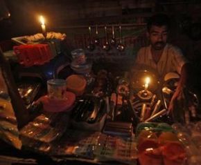 A gas oven mechanic waits for customers in his shop during a power-cut in Kolkata 