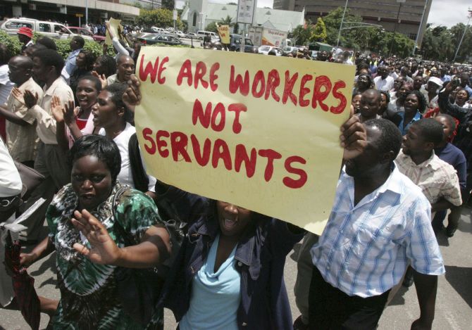 Zimbabwe's civil servants carry placards as they march during a protest.