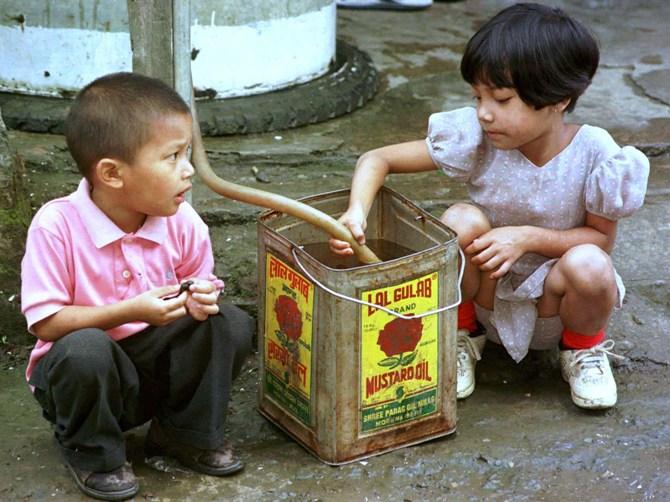 Children fill a cannister with drinking water from a public tap in Aizawl, Manipur..