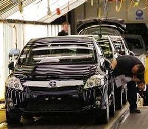 A worker inspecting cars at the Toyota factory.