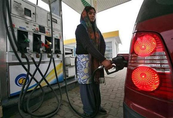 An employee fills a vehice with petrol at a fuel station in Jammu.