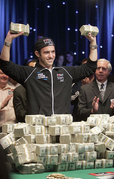 Joe Cada, a poker professional, celebrates with bundles of cash after winning $8.5 million in prize money.