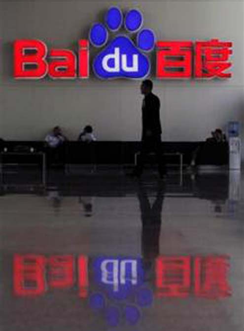 A security guard walks past the company logo of Baidu at its headquarters in Beijing