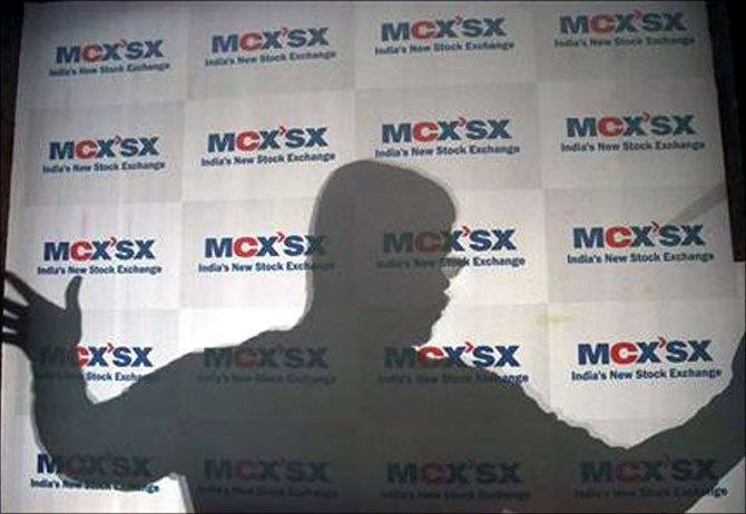 A man moves an advertising poster bearing the MCX-SX logo.