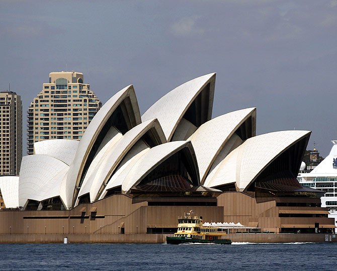 A cruise liner is seen behind the Sydney Opera House along the central business district in Sydney.