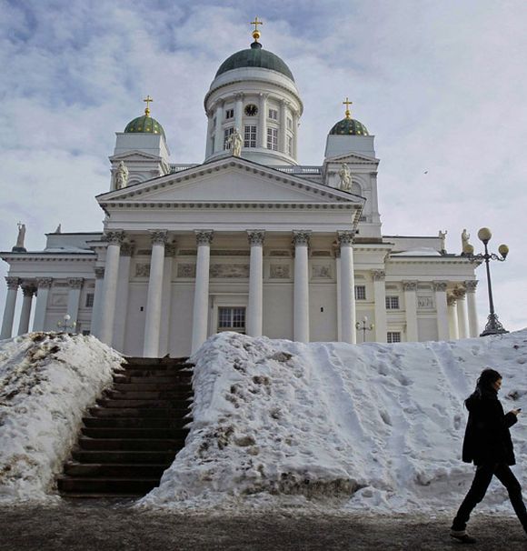 A woman walks past Helsinki cathedral.