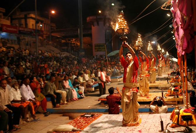 Hindu priests hold fire lamps as they perform evening prayers on the banks of river Ganges in Varanasi.